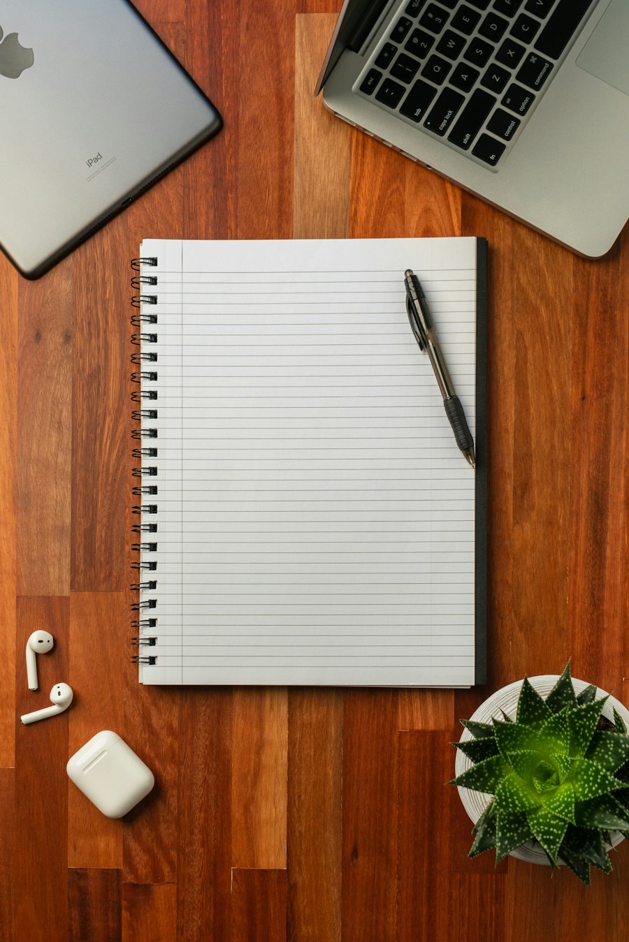 A notebook and pen on a wooden desk